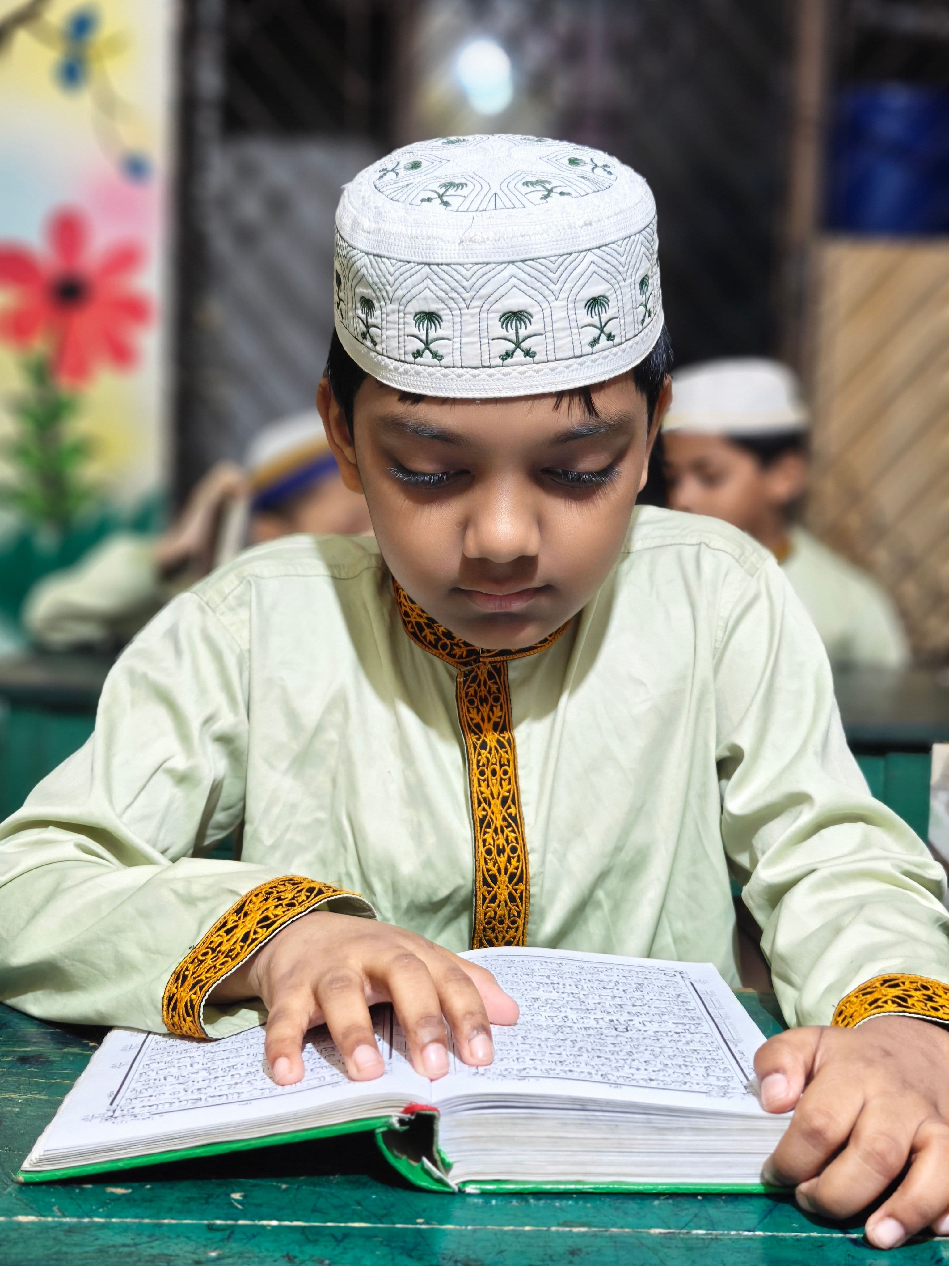 A young student reading the Quran during a live online class