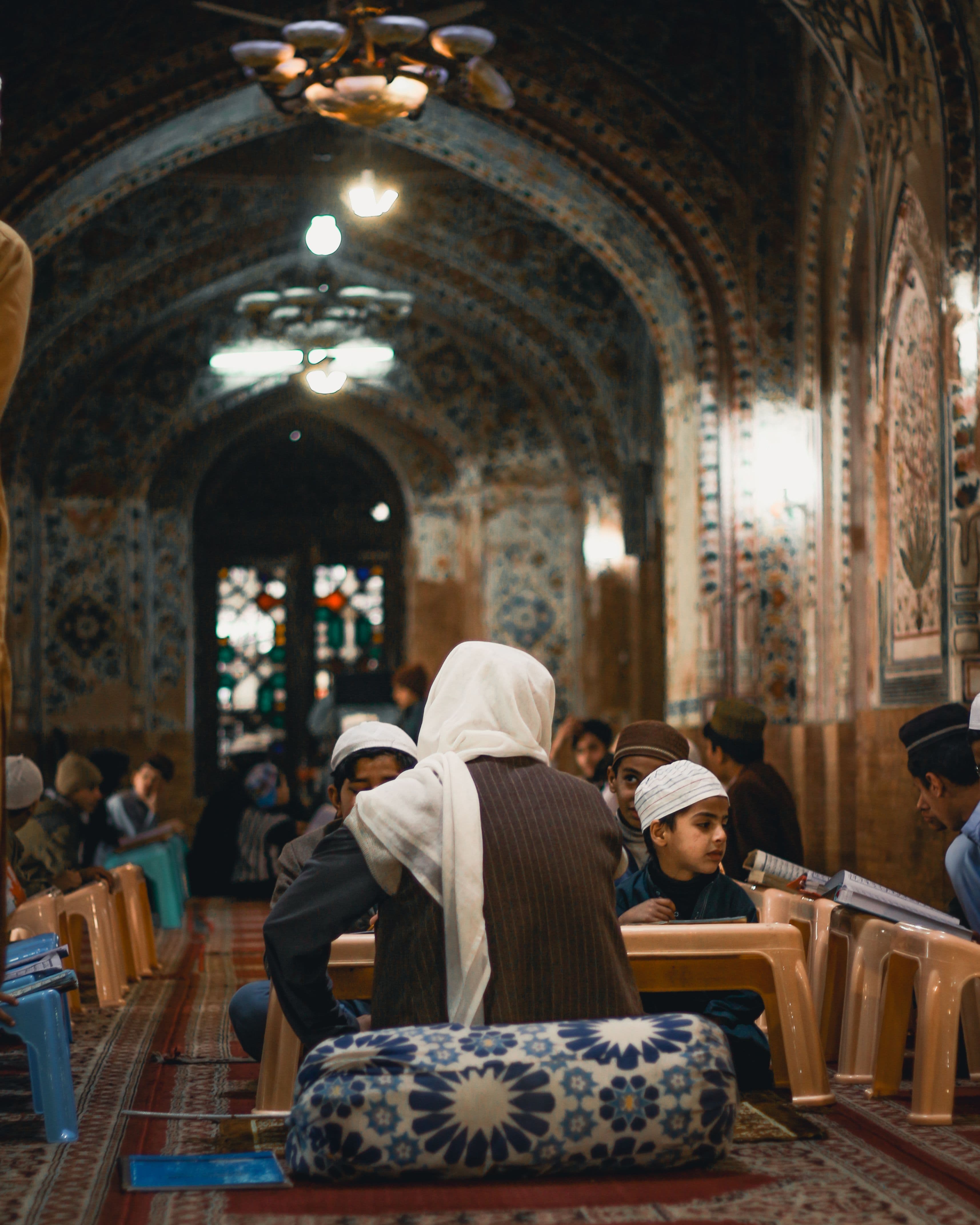 Students learning the Quran with a teacher in a traditional study hall