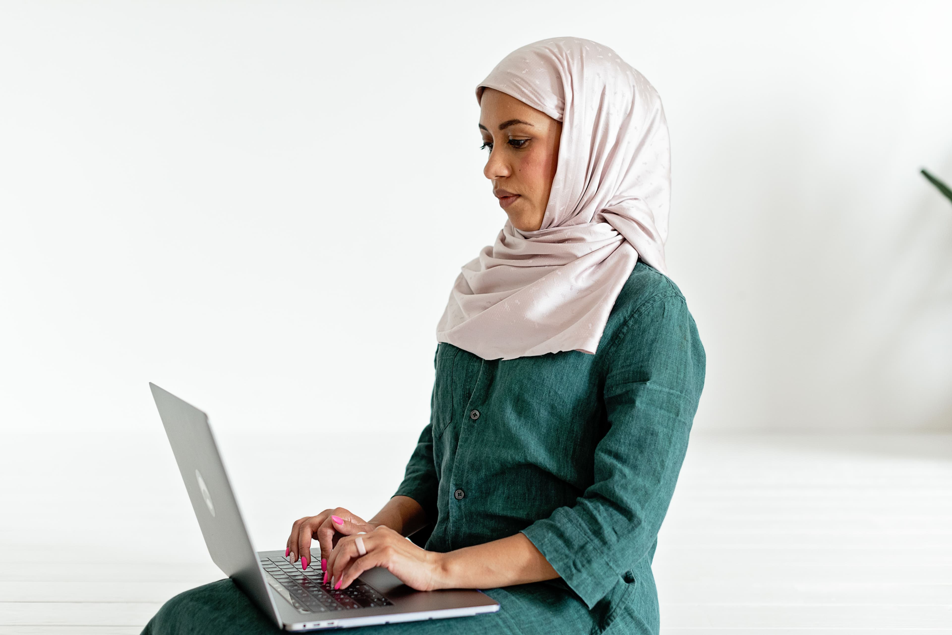 Muslim woman using a laptop for online learning